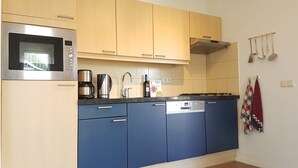 A kitchen with a microwave, coffee maker, and dishwasher. - Horizon 95 Comfortable villa with boxspring on vacation park (Renesse)