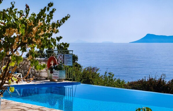 A pool with a lifebuoy, a sign prohibiting diving, and a view of the sea. - Villa Pelagos Kyma in Lefkada (Lefkada)
