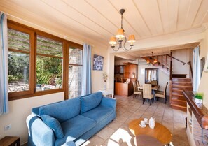A living room with a sofa, a coffee table, and a staircase leading to a kitchen. - Villa Pelagos Kyma in Lefkada (Lefkada)