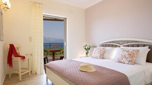 A bedroom with a bed, a chair, a table, a window with a view, and a balcony. - Villa Melanthi in Lefkada (Lefkada)