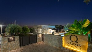 A stone wall with a sign for Omega Luxury Villa. - Villa Omega in Alonnisos (West Mani)