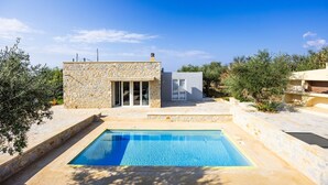 A modern house with a swimming pool, stone walls, and a clear blue sky. - Villa Omega in Alonnisos (West Mani)