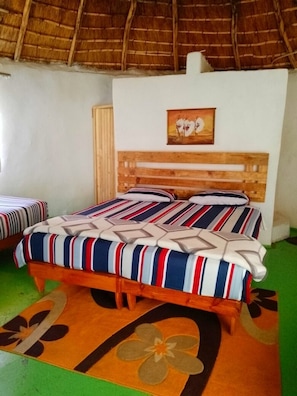 Una habitación con cama, cabecera de madera, un cuadro y alfombra verde.