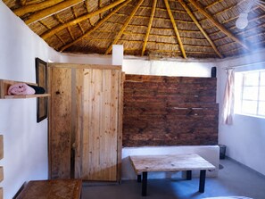 A room with a wooden door, a bench, and a table. - Ha Ramabanta Park (Ramabanta)