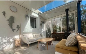 Ein modernes Wohnzimmer mit einer Couch, einem Couchtisch, einem Kamin und einem großen Fenster.