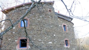 Un bâtiment en pierre doté de nombreuses fenêtres et d’une porte bien visible.
