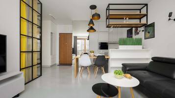 A modern living room with a black sofa, a white coffee table, and a dining area with a white table and chairs.