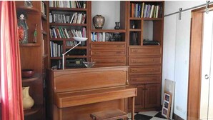 Ein Zimmer mit einem Holztisch, Bücherregalen und einem Schachbrettmuster-Boden.