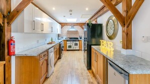 A kitchen with wooden beams, a clock, and a 'FAR' sign.