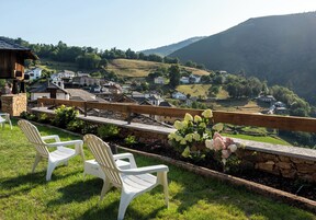 Una vista pintoresca de un pueblo con muros de piedra, casas blancas y una valla de madera.