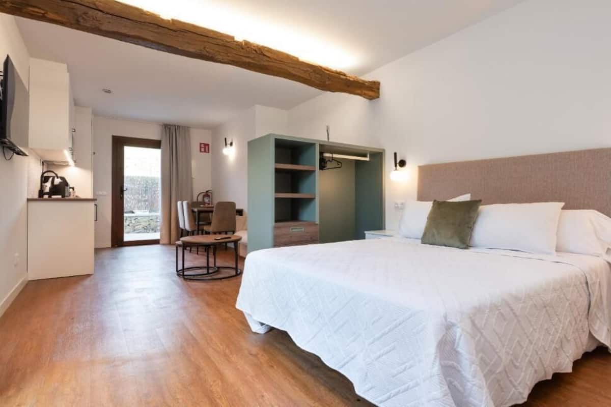 A bedroom with a bed, a wardrobe, a chair, and a desk.