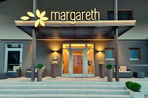 Un bâtiment moderne avec une enseigne portant l’inscription « margareth » et un escalier menant à une porte.