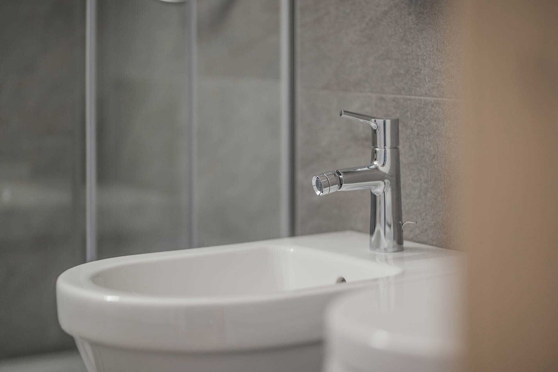A bathroom with a white sink and a chrome faucet.
