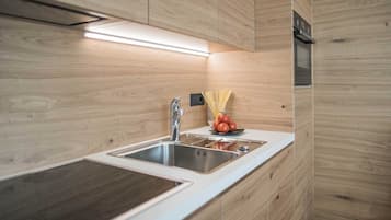 Cafetera o tetera, frigorífico, microondas y placa de cocina