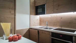 Een moderne keuken met houten kastjes, een roestvrijstalen spoelbak, een magnetron en een oven.