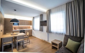 A modern living space with a kitchen, dining area, and a cozy seating area. - Three-Room Apartment 'Type C 74m²' with Mountain View, Balcony and Wi-Fi (Campo Tures)