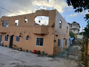 A residential building with a unique architectural design, including a large arched window and multiple balconies. - White River Villa (Ocho Rios)