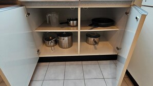 Une cuisine dotée d’une lucarne, de meubles blancs et d’un sol carrelé.
