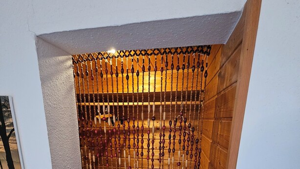 Un coin de pièce avec un mur en bois et un plafond blanc.