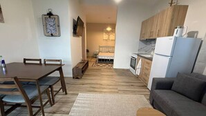 A compact living space with a dining area, kitchenette, and a sofa. - Sunrise Beach Front Villa (Nea Propontida)