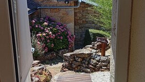 A stone building with a wooden deck leading to a stone wall and a sign pointing to 'Gile Lili.' - Lili de la Lisathi (Palmas d'Aveyron)