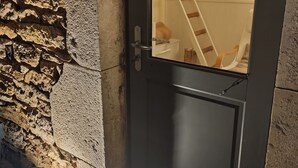 A stone wall with a door, a staircase, and a sign with the name 'Lili.' - Lili de la Lisathi (Palmas d'Aveyron)