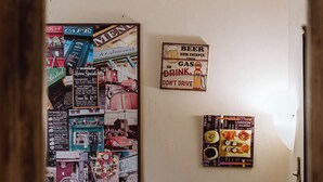 A wall with various posters, including a beer sign and a sushi sign. - Claudio Flat - Metro Re di Roma (Rome)