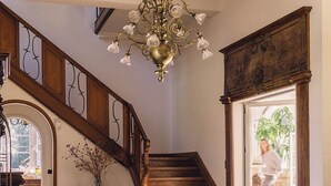A spacious foyer with a grand staircase, a chandelier, and a resting dog. - Bleyckhof is a unique old bleachery in natural area. Country house with private park (Ranst)