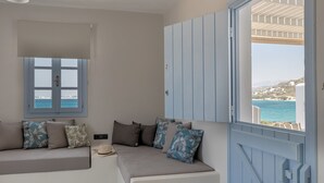 A room with a sofa, a window with a view of the sea, and a door with a view of the sea. - STUDIOS KONTOS (Naxos)