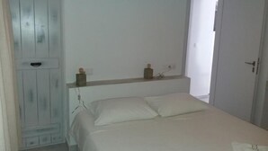 Ein Schlafzimmer mit einem Bett, einem Kleiderschrank und einer Tür zu einem anderen Raum.