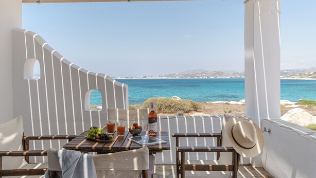 Eine Terrasse mit Tisch für zwei Personen, mit Blick auf die Küste.