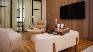 Ein modernes Wohnzimmer mit einer Couch, einem Couchtisch, einem an der Wand befestigten Fernseher und Holzböden.