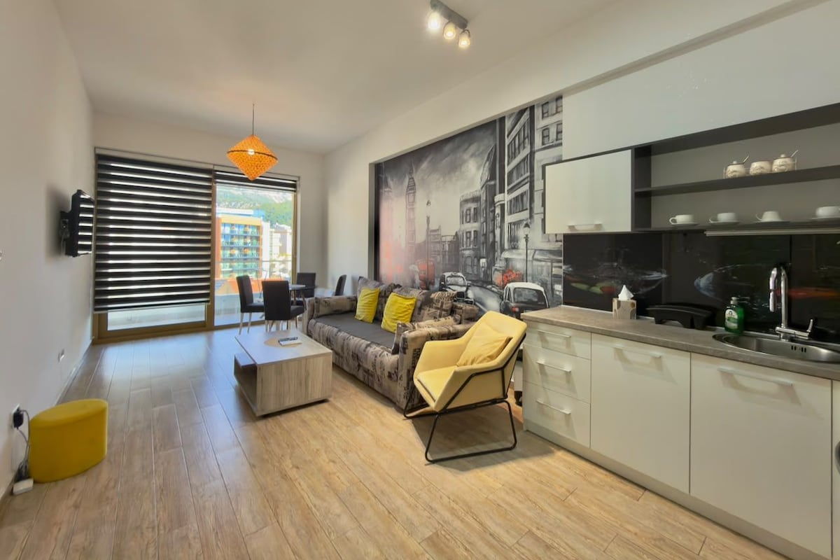 A modern living room with a sofa, coffee table, and a dining area.