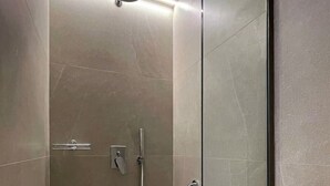 A modern shower with a handheld showerhead, a wall-mounted control panel, and a glass door. - Local Suite 3 - Nea Moudania (Nea Moudania)