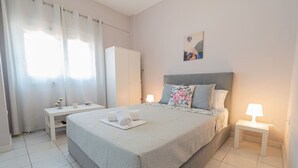 Quarto bem arrumado com uma cama, mesas de cabeceira, um guarda-roupa e um quadro na parede.