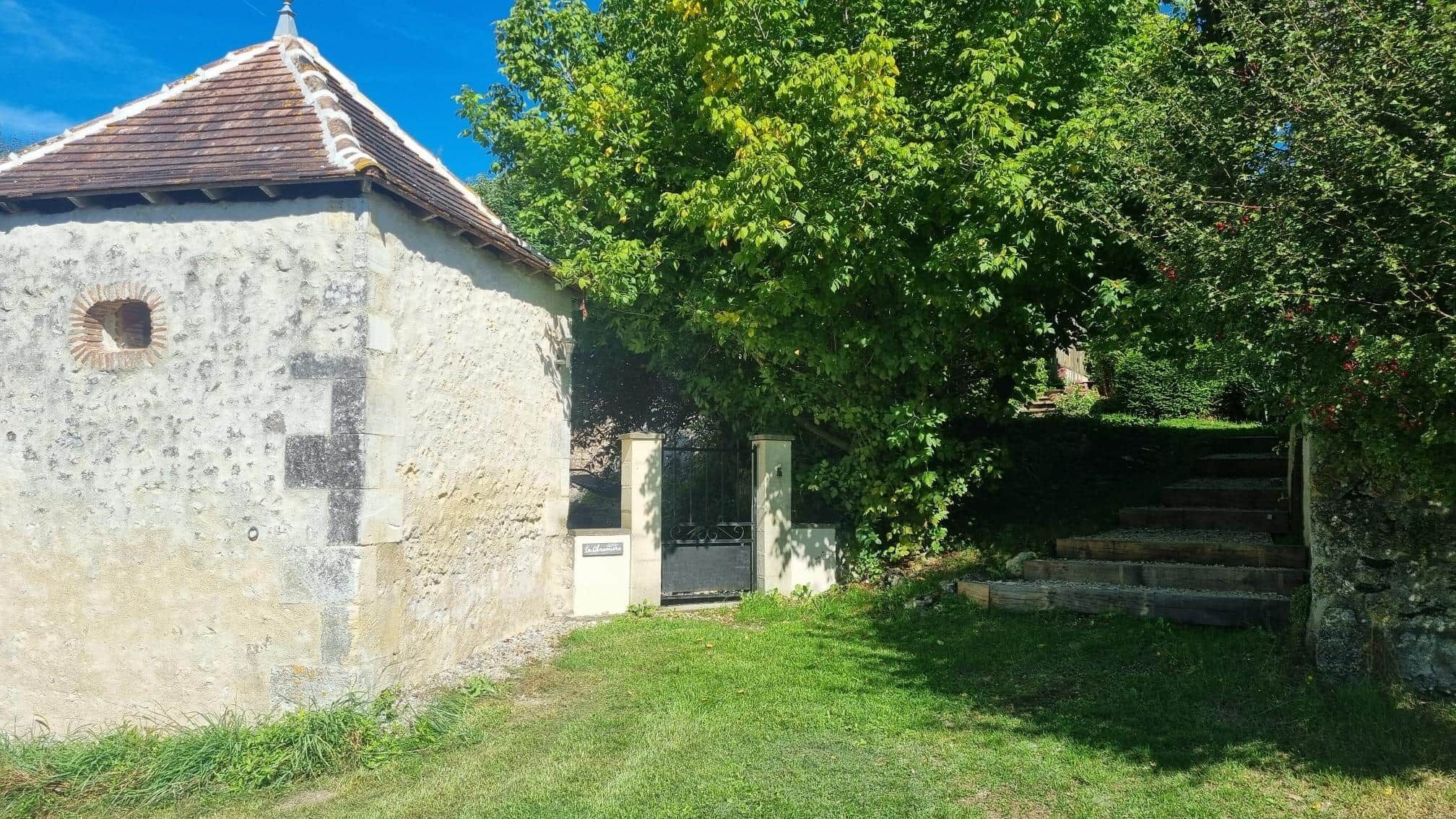 Un edificio rustico con tetto in tegole, una piccola finestra e una porta in legno.