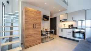 Eine moderne Küche mit Essbereich, einem Holzschrank und einer Treppe zu einer oberen Ebene.