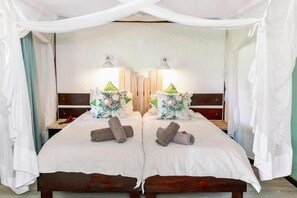 A mirrored room with a bed, pillows, and bedside lamps. - Okahandja Country Hotel (Okahandja)