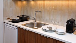 Een moderne keuken met een roestvrijstalen spoelbak, een fornuis en een koffiezetapparaat.