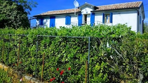A white building with blue shutters and a satellite dish, surrounded by greenery. - Authentic Istrian Apartments Villa Zambratija (Umag)