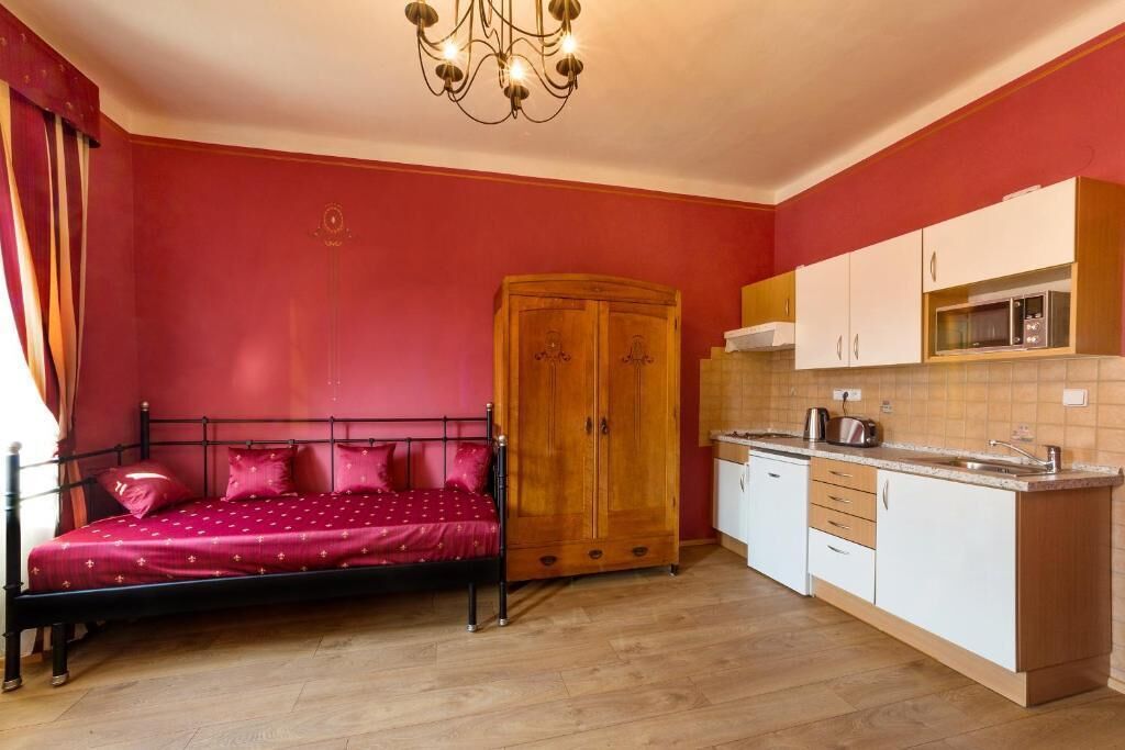Een slaapkamer met een bed, een kast en een kitchenette.
