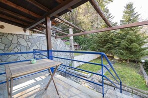 A stone wall, a wooden table, and a blue railing.