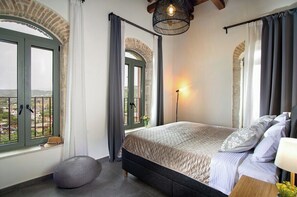 A bedroom with a bed, a lamp, a window, and a view of the outside. - Vineyard View, next to Best Wineries, "Trigos" appartment (52QJ+W6 Avgeniki)