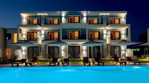 A modern hotel with a pool, multiple balconies, and outdoor seating. - Calda Resort (Polygyros)