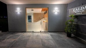 A modern building entrance with a glass door, a staircase, and a sign for 'CALDA RESORT & SPA'. - Calda Resort (Polygyros)