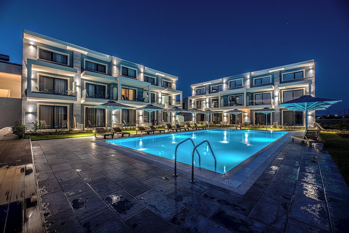 Um hotel moderno com piscina, várias varandas e áreas de estar ao ar livre.