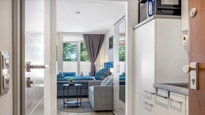 Une cuisine moderne avec des meubles blancs et une porte en bois.