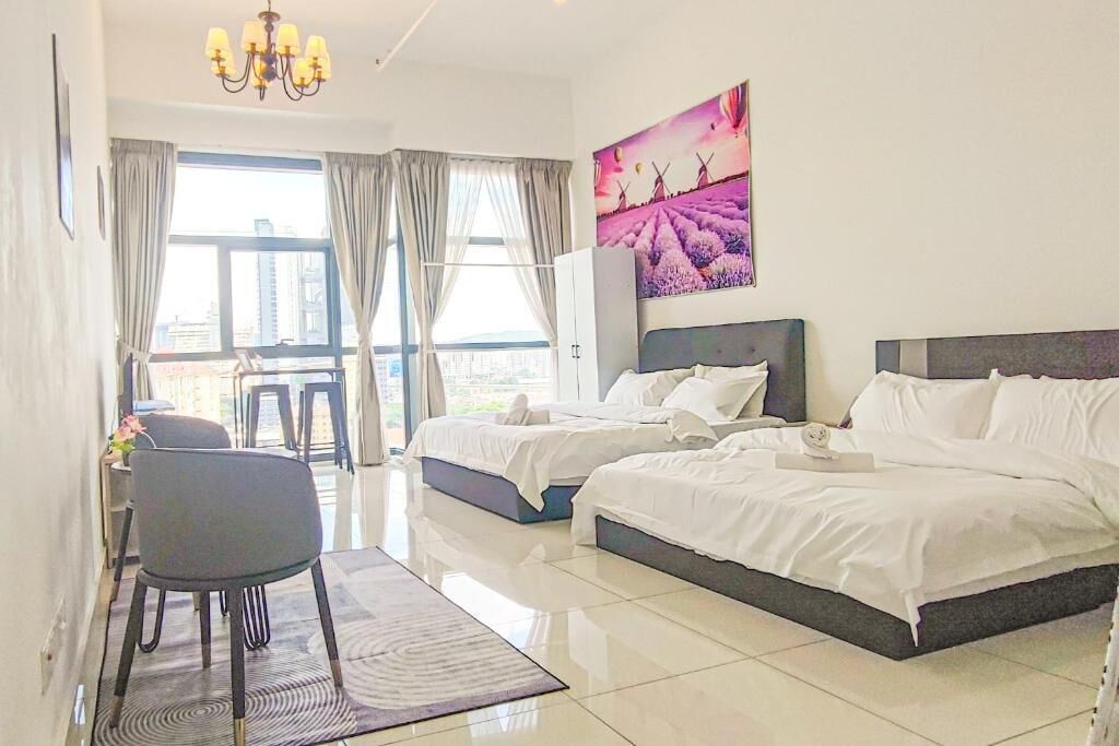 A hotel room with two beds, a dining area, and a large window with curtains.