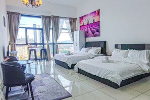 A hotel room with two beds, a dining area, and a view of the city. - Sky Pool at 3 Towers Ampang by HCK (Kuala Lumpur)