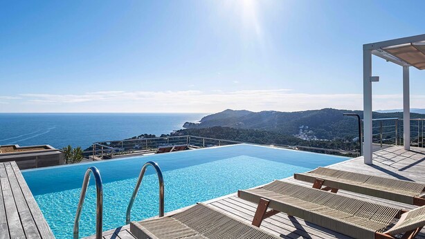 En pool med utsikt över havet och bergen.